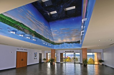 large lobby with stone floors and ceiling mural