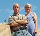 Ted Milks and Dottie Weinstein standing on a staircase below blue sky
