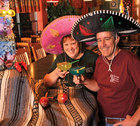 Jeanette and Jim Wood drinking margaritas and wearing sombreros