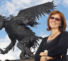 Mira Niagolova in front of a large, black, winged creature