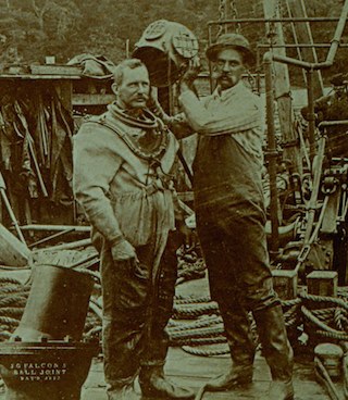 historic image of diver being suited with hard helmet